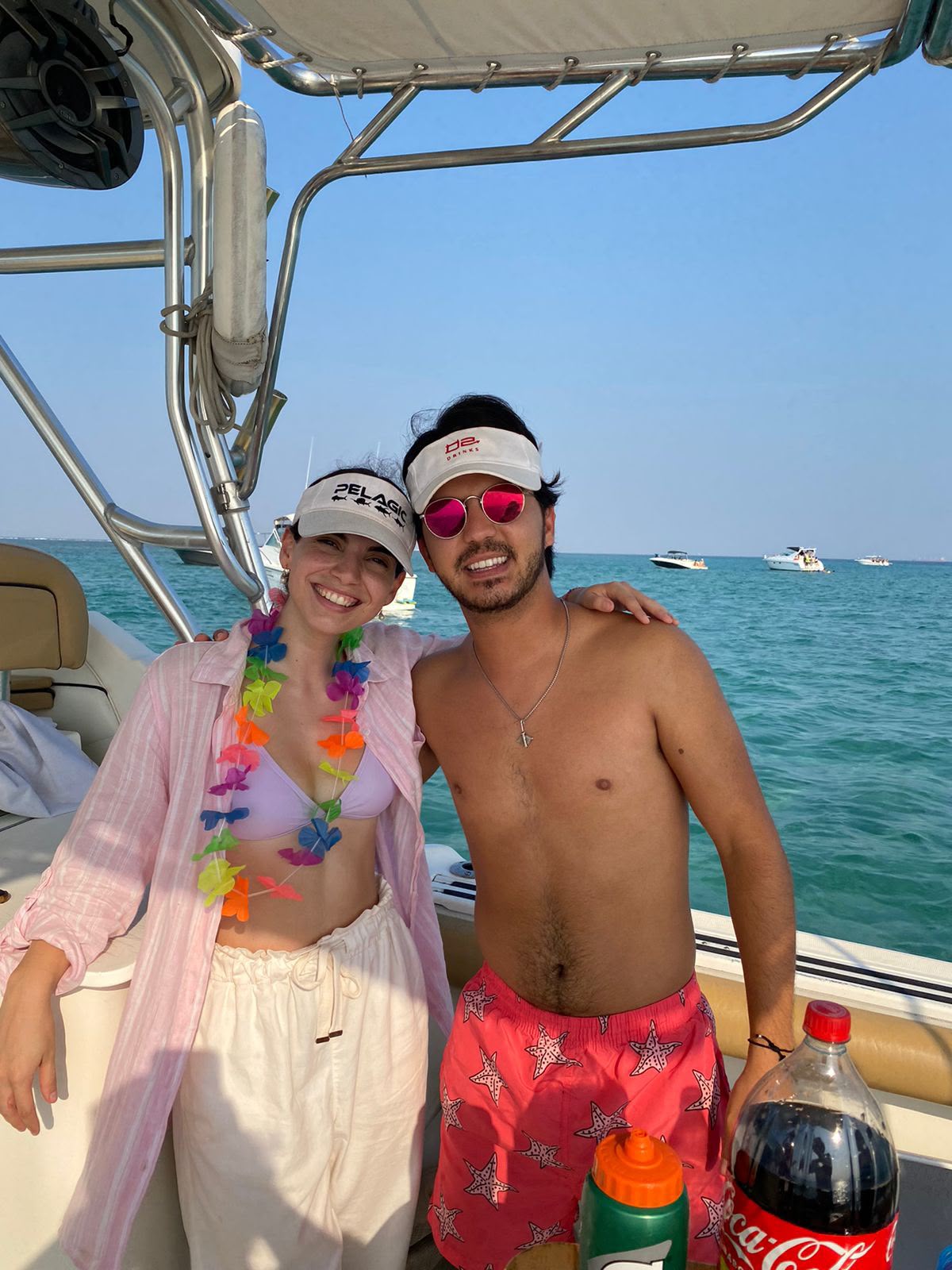 Pareja de amigos posando a bordo en aguas turquesa